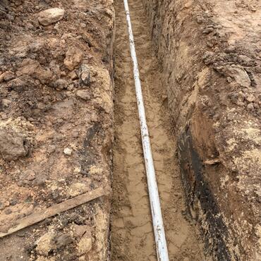 3” pipe in already excavated trench and bed in sand